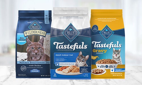 Image of three bags of dry cat food on a white marble countertop 